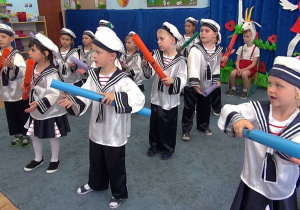Dzieci-marynarze tańczą z bum bum rurkami w rękach